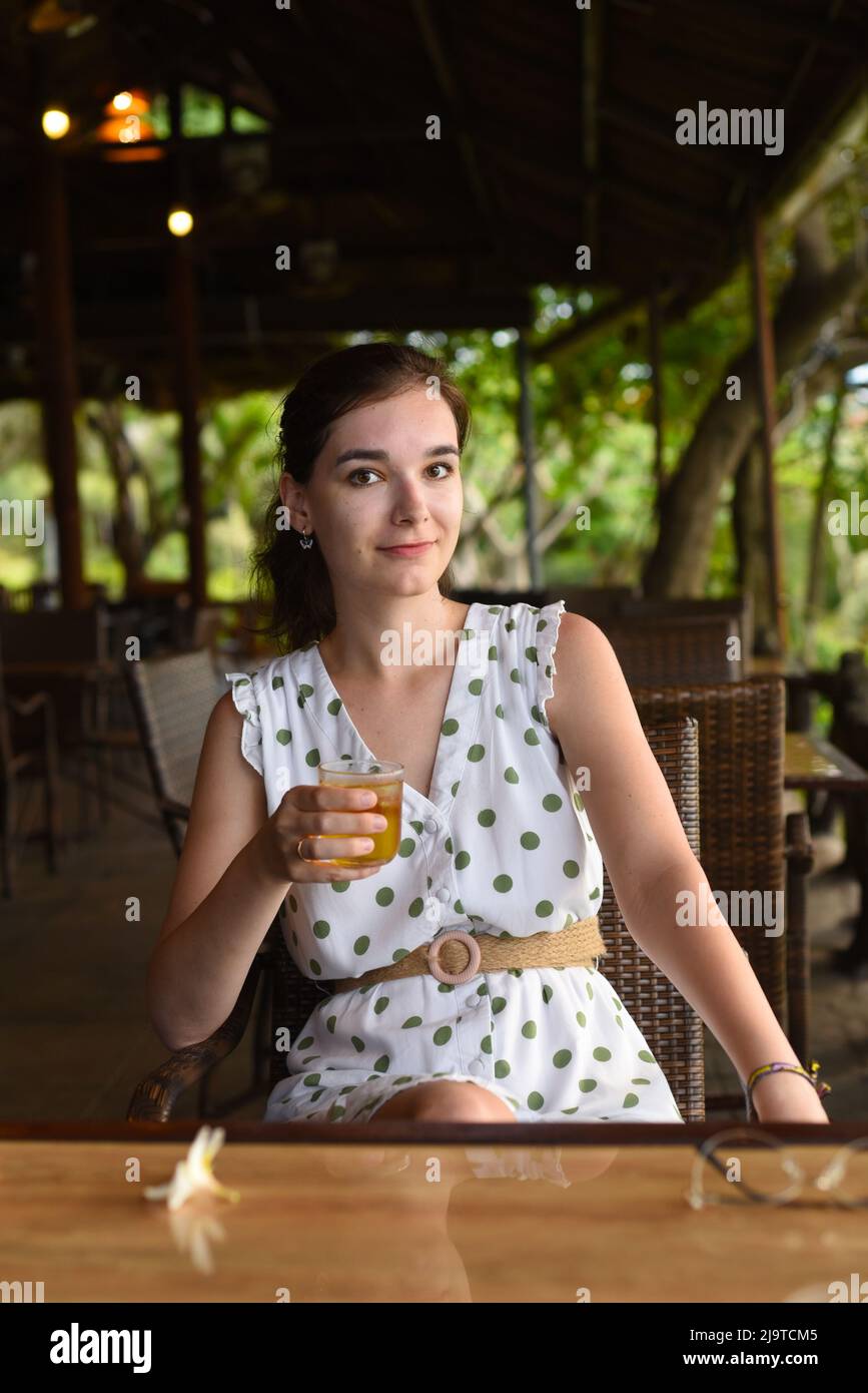 Junge Frau trinkt lokalen vietnamesischen grünen Tee mit Eis im Café von Nha Trang Stockfoto