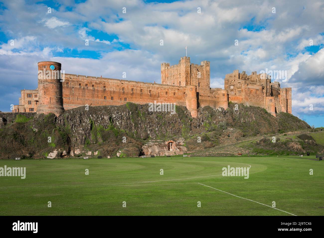 Northumberland Castle, Blick im Sommer auf Bamburgh Castle (aus dem 12.. Jahrhundert), das sich über dem Dorf Bamburgh an der Küste von Northumberland, Großbritannien, befindet Stockfoto