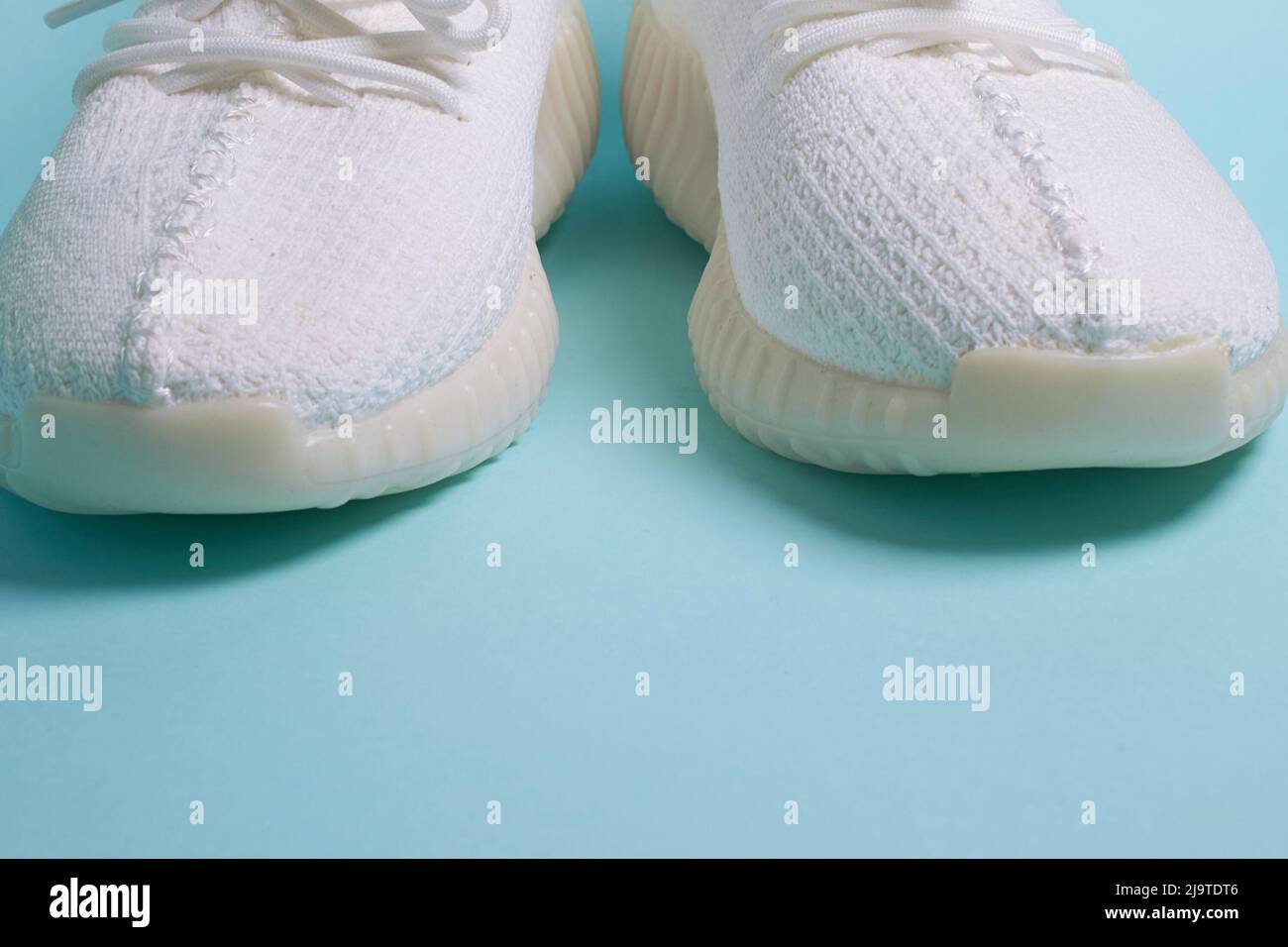 Ein Paar weiße Sneakers auf blauem Hintergrund Stockfoto