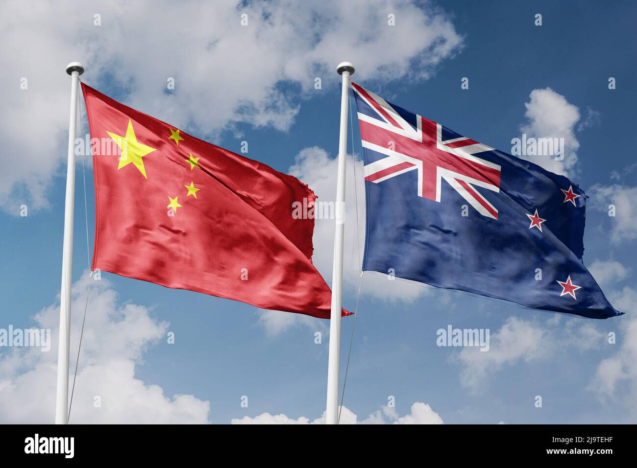 Neuseeland und China zwei Flaggen auf Fahnenmasten und blau bewölktem Himmel Hintergrund Stockfoto