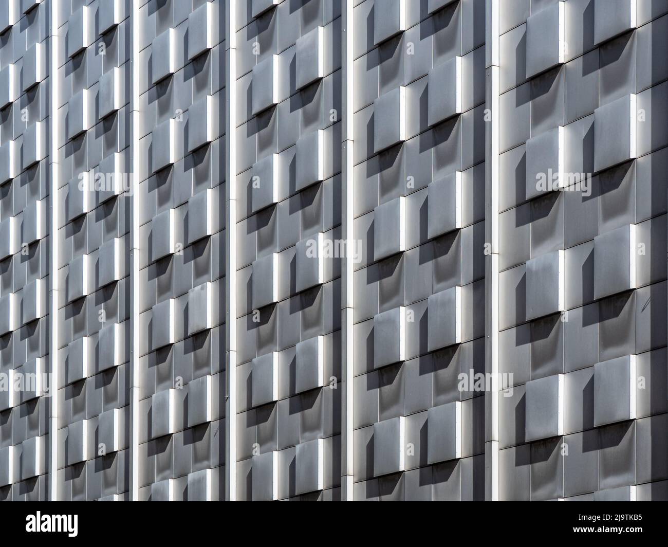 Betonziegelwand Hintergrund mit dem Licht und Schatten auf den Ziegel in Gruppe Muster der Wellenbewegung extrudiert von der Außenfassade Gebäude. Stockfoto