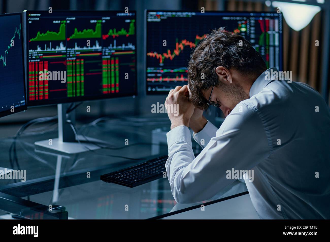 Besorgt junger Investor sitzt an einem Computer-Schreibtisch . Stockfoto