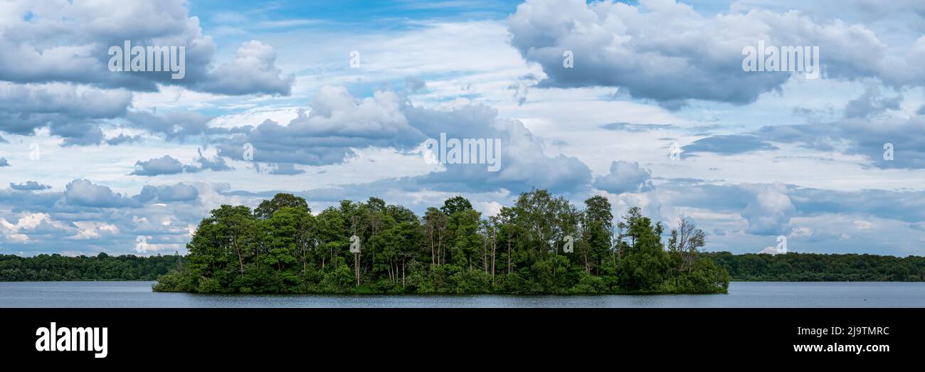 Panoramabild der Bauminsel in der Mitte des Sees mit dramatischen Wolken Stockfoto