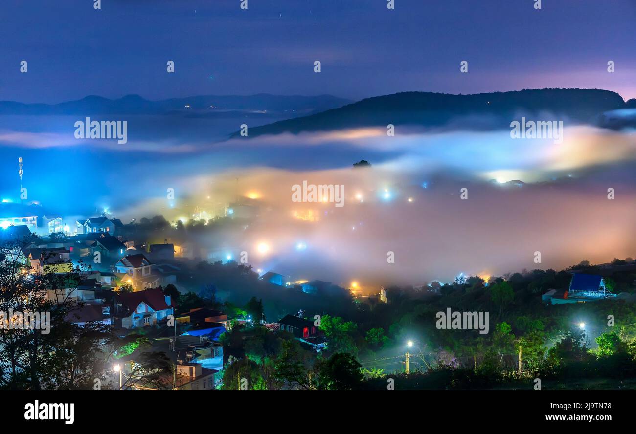 Die Abendlandschaft im Tal, die mit Nebel bedeckt einschläft, ist so verschwommen, so schön und friedlich Stockfoto
