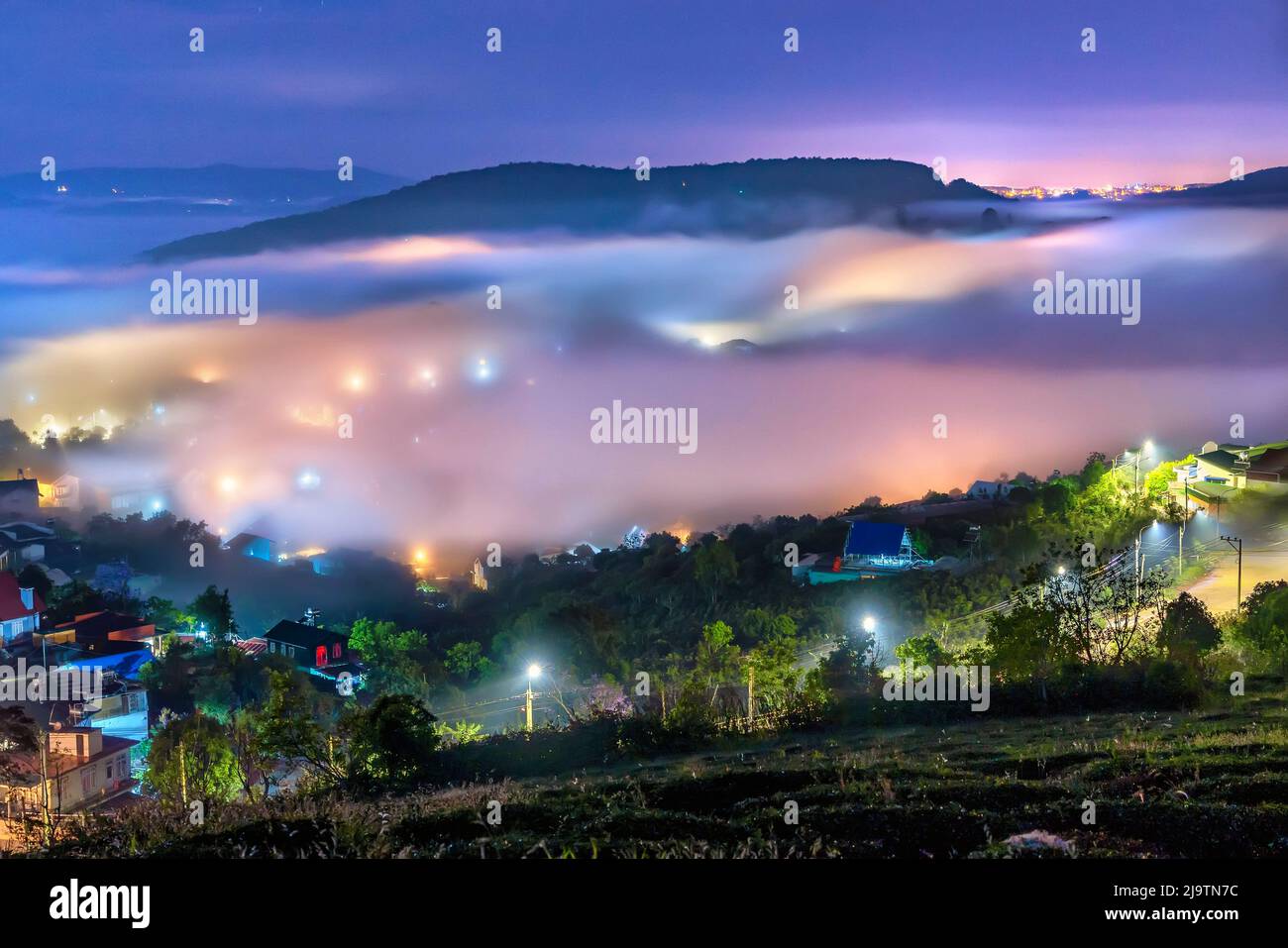 Die Abendlandschaft im Tal, die mit Nebel bedeckt einschläft, ist so verschwommen, so schön und friedlich Stockfoto