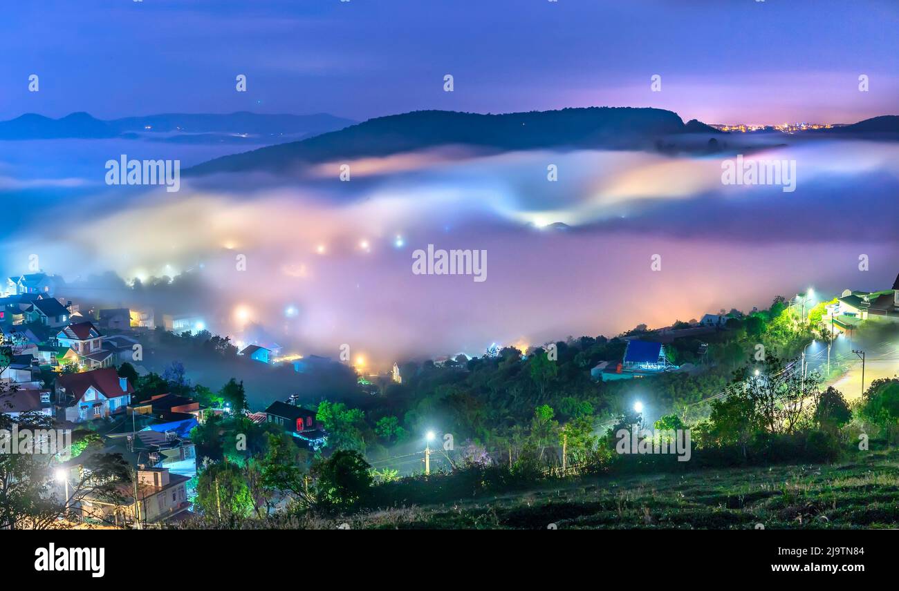 Die Abendlandschaft im Tal, die mit Nebel bedeckt einschläft, ist so verschwommen, so schön und friedlich Stockfoto