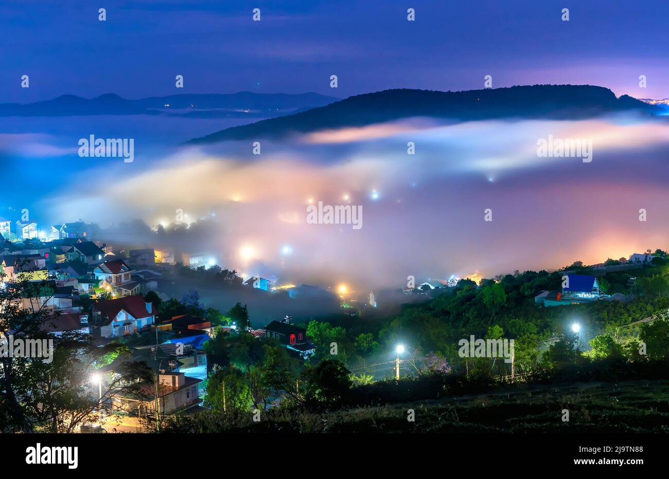 Die Abendlandschaft im Tal, die mit Nebel bedeckt einschläft, ist so verschwommen, so schön und friedlich Stockfoto