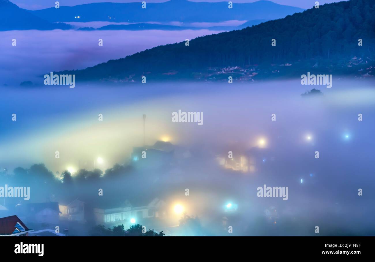 Die Abendlandschaft im Tal, die mit Nebel bedeckt einschläft, ist so verschwommen, so schön und friedlich Stockfoto