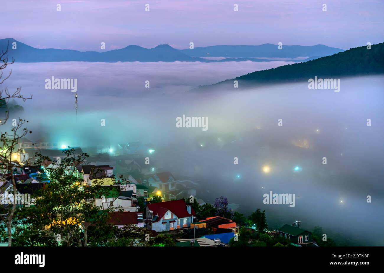 Die Abendlandschaft im Tal, die mit Nebel bedeckt einschläft, ist so verschwommen, so schön und friedlich Stockfoto