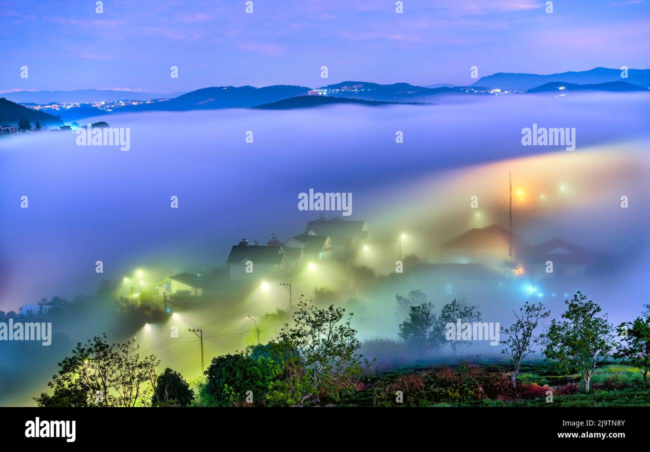 Die Abendlandschaft im Tal, die mit Nebel bedeckt einschläft, ist so verschwommen, so schön und friedlich Stockfoto