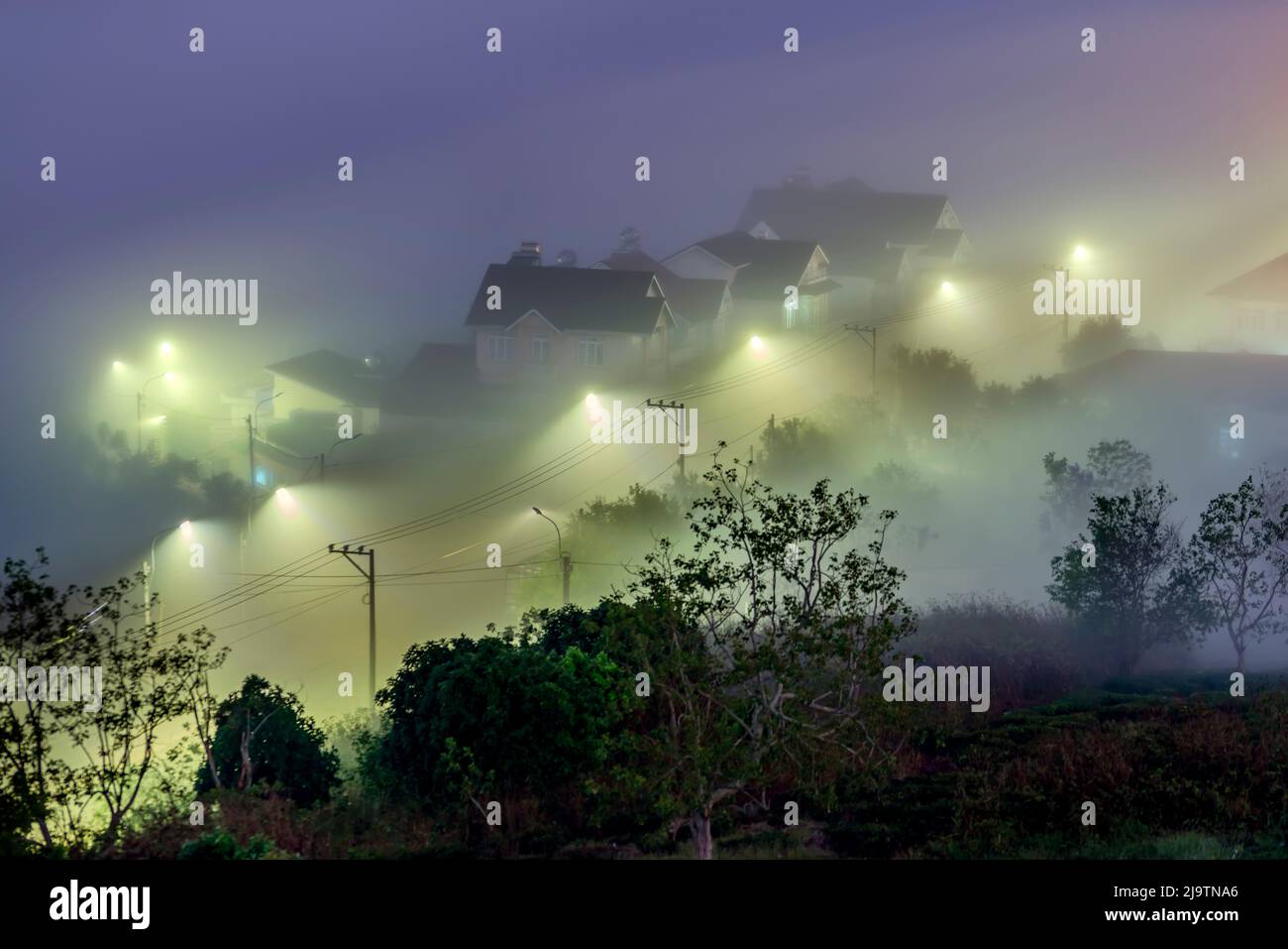 Die Abendlandschaft im Tal, die mit Nebel bedeckt einschläft, ist so verschwommen, so schön und friedlich Stockfoto