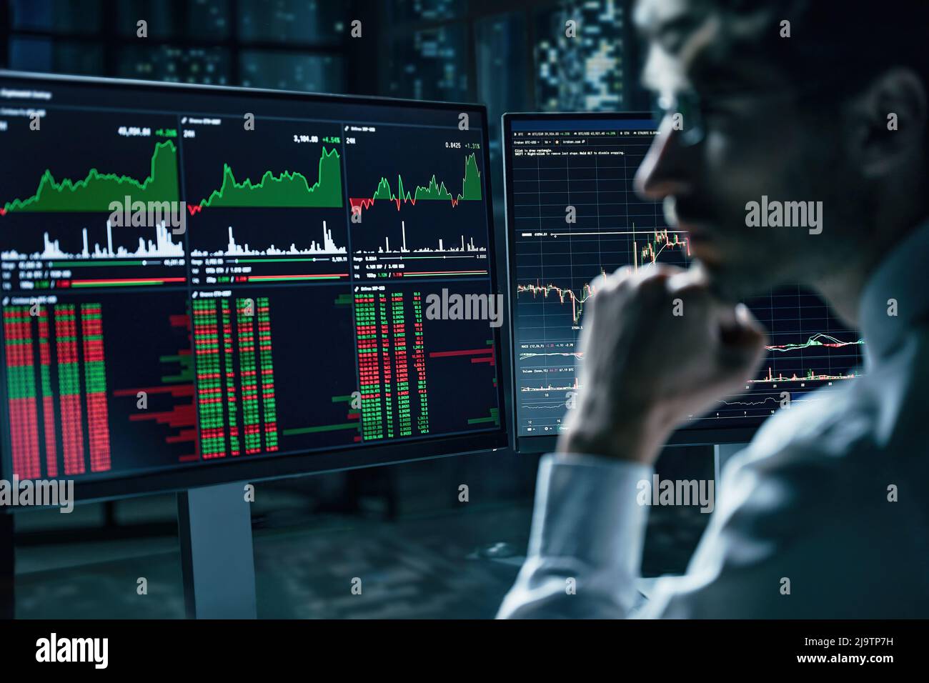 Monitore mit Diagrammen von Aktien, Rohstoffen und Aktienmärkten auf dem Schreibtisch des Geschäftsmannes. Stockfoto