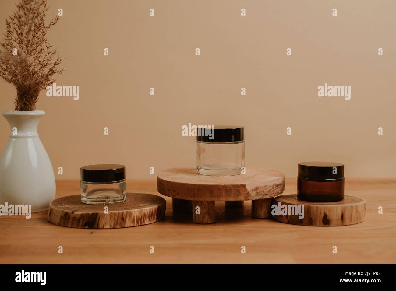 Holzbühne mit Containern und beigem Hintergrund Stockfoto