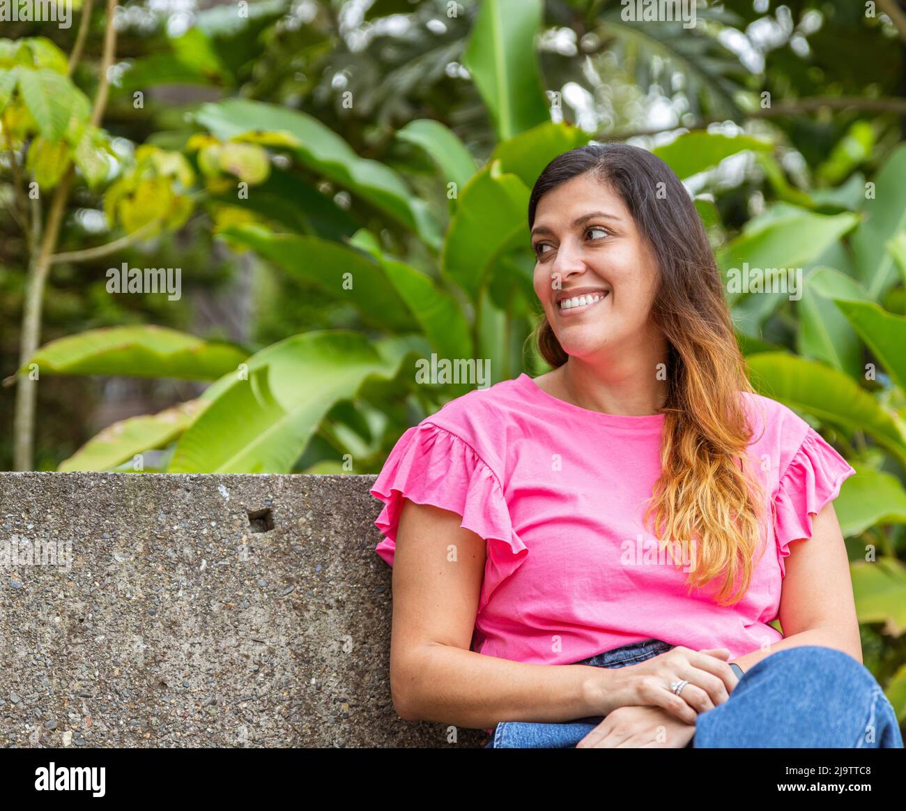 latina Frau sitzt auf einer Bank im Park Stockfoto