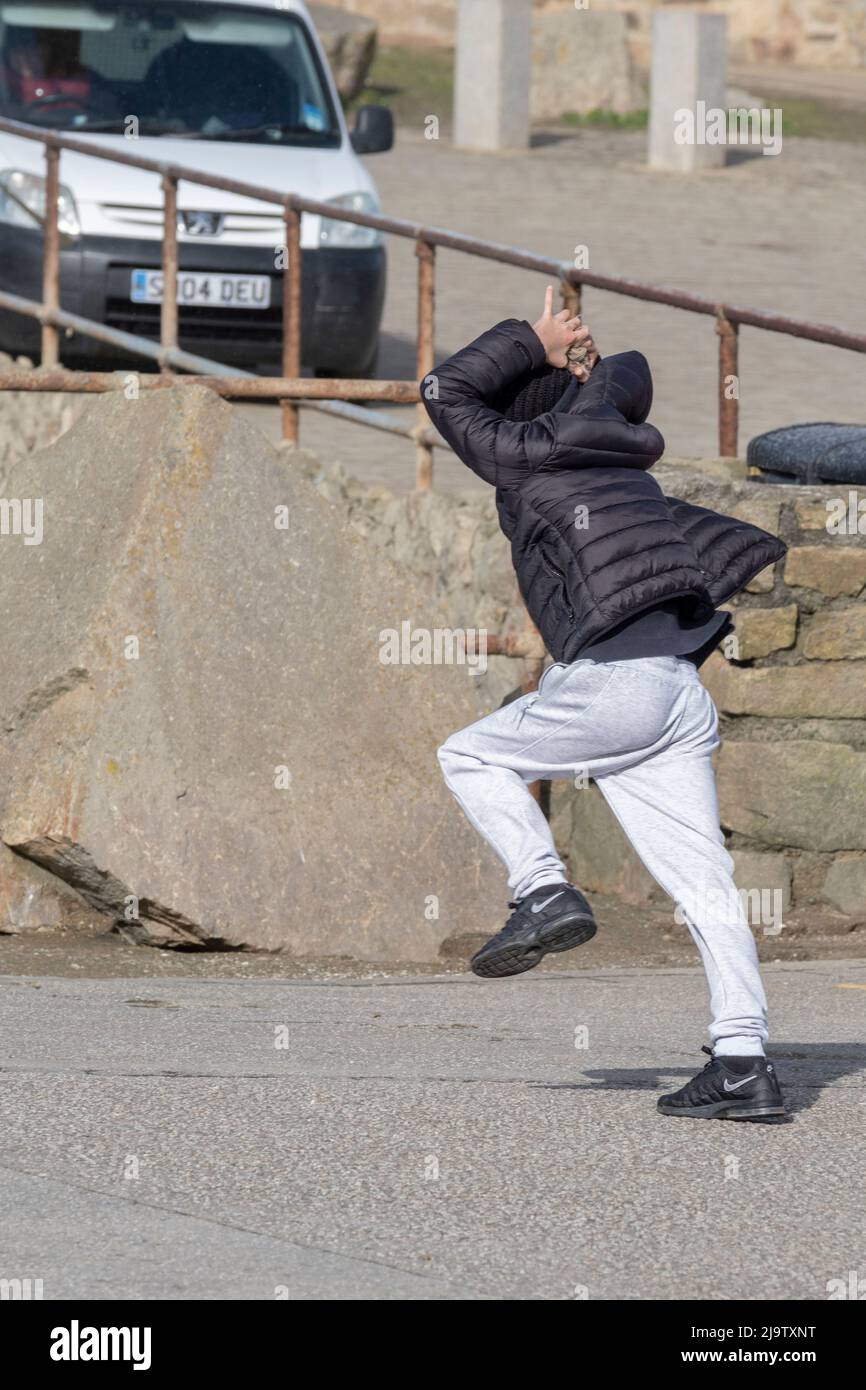 Ein kleiner Junge, der sich mit starken Sturmwinden durch Sturm Eunice herumschlagen muss, während er die Küste um Newquay in Cornwall kämpft. Stockfoto