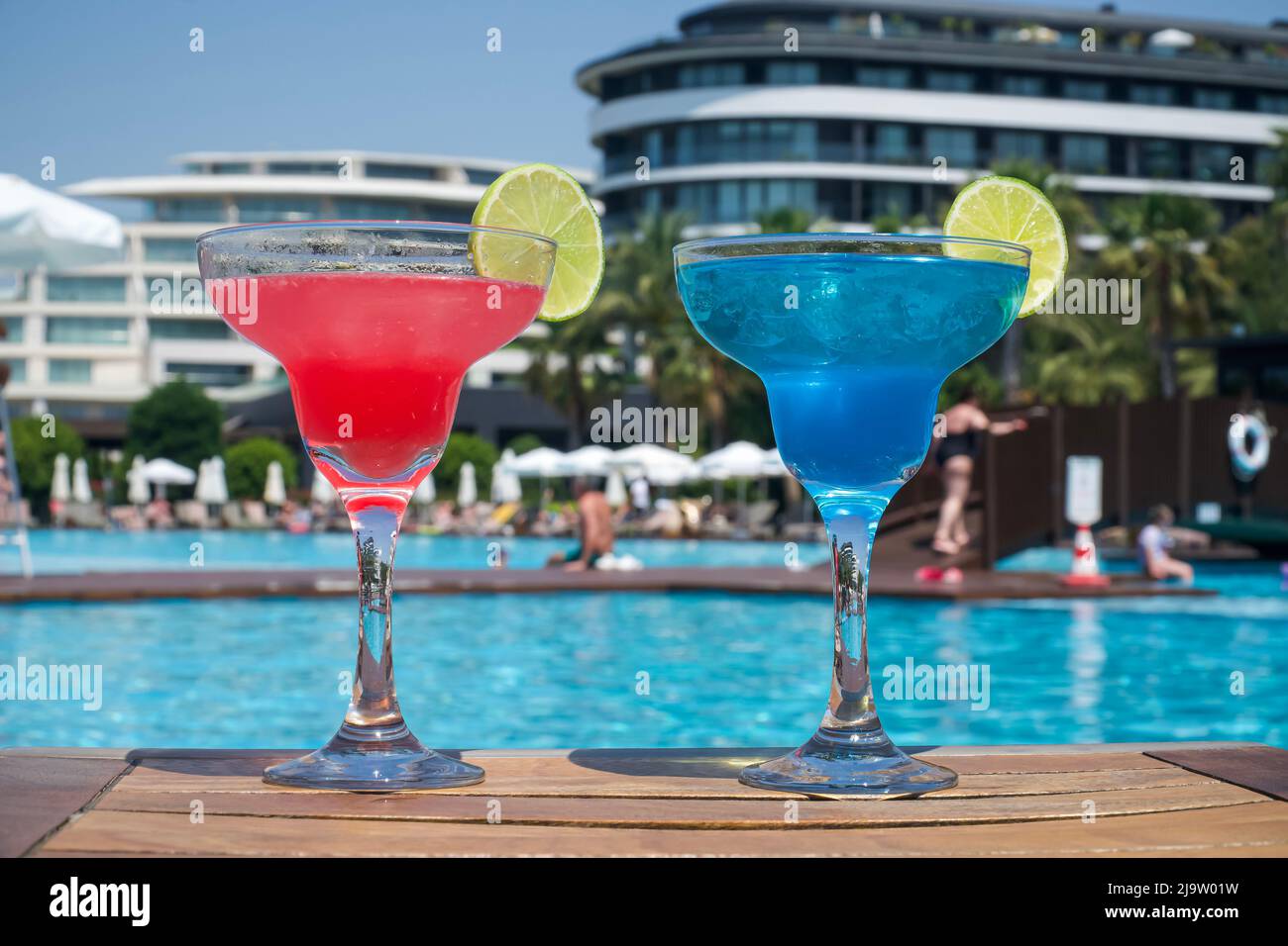 Zwei Cocktails am Pool. Roter und blauer Cocktail auf einem Holztisch, im Urlaub Stockfoto