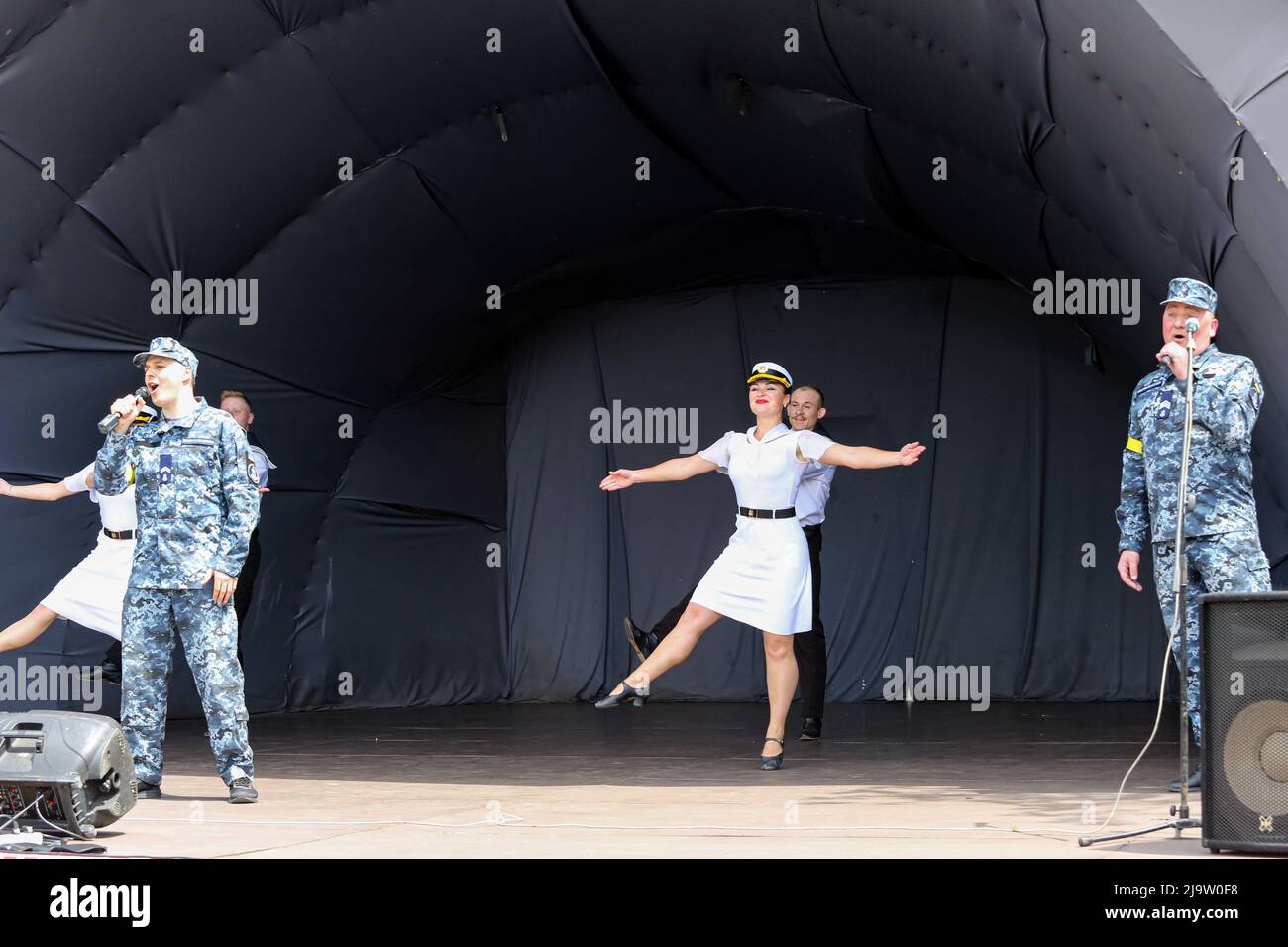 Männer in Uniform der ukrainischen Streitkräfte singen und tanzen mit Frauen in Uniform der ukrainischen Marine während eines Konzerts im Rahmen der militärisch-patriotischen Aktion "unterstütze deine Unterstützung". Im Park namens T.G. Schewtschenko, ein Konzert des Offiziershauses fand auf der Rakuschka-Bühne statt. Ziel der Aktion ist es, die Streitkräfte und die Moral der Bevölkerung zu unterstützen. Stockfoto