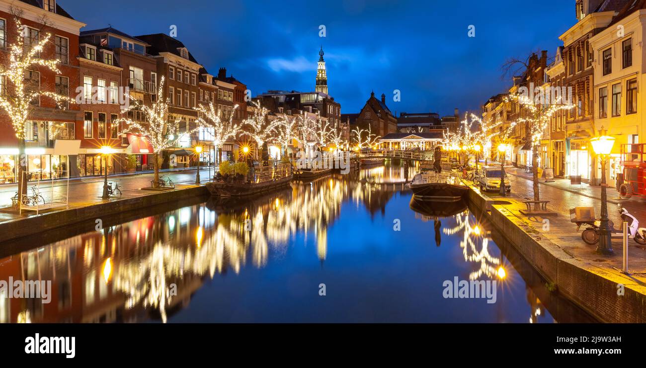 Nacht Leiden Kanal Oude Rijn, Rathaus und Brücke Koornbrug in Weihnachtsbeleuchtung, Südholland, Niederlande. Stockfoto