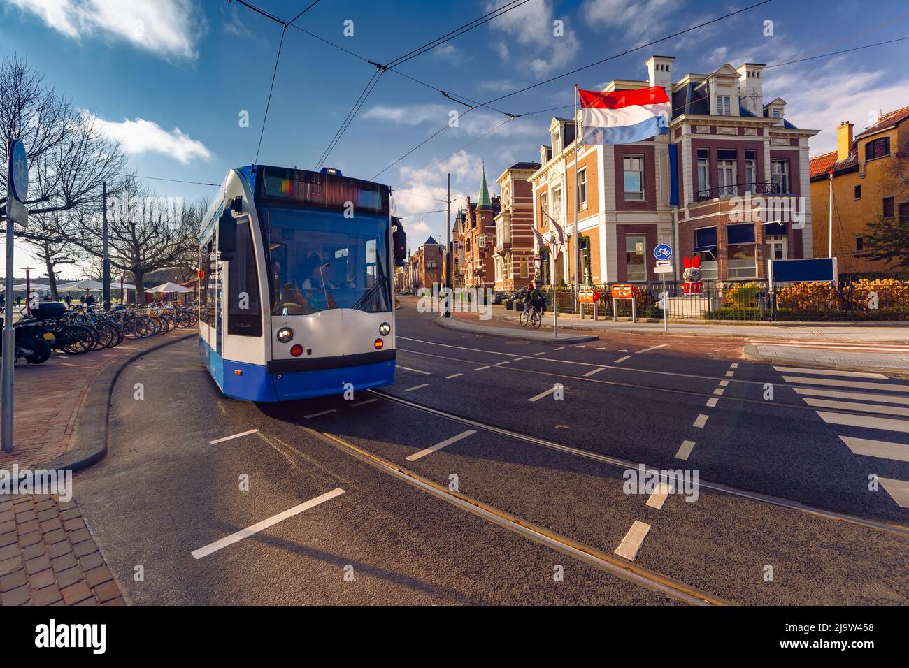 Amsterdamer Straßenbahn, niederländische Flagge vor dem Hintergrund typischer holländischer Häuser, Holland, Niederlande. Stockfoto