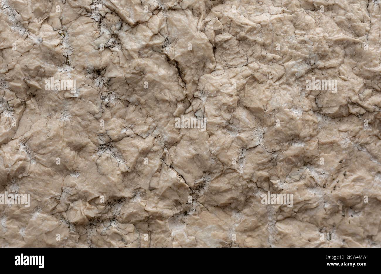 Cremefarbene holprige Stein Hintergrund mit Rissen ein Spalten Stockfoto
