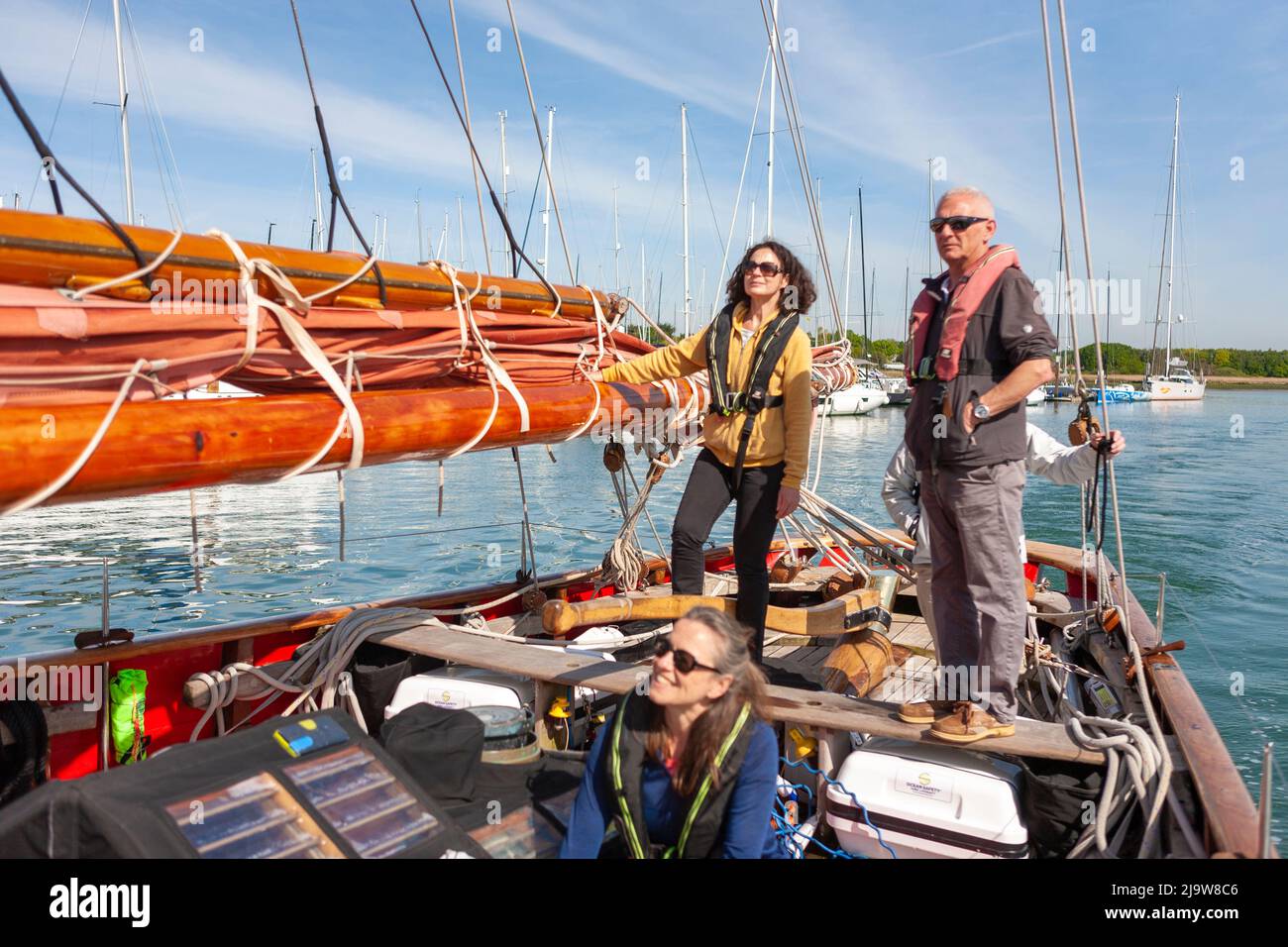 Skipper Toby Marris überwacht seinen Steuermann, der den berühmten Gaffelschneider „Jolie Brise“ den Fluss Hamble, Hampshire, Großbritannien, hinuntersteuert Stockfoto