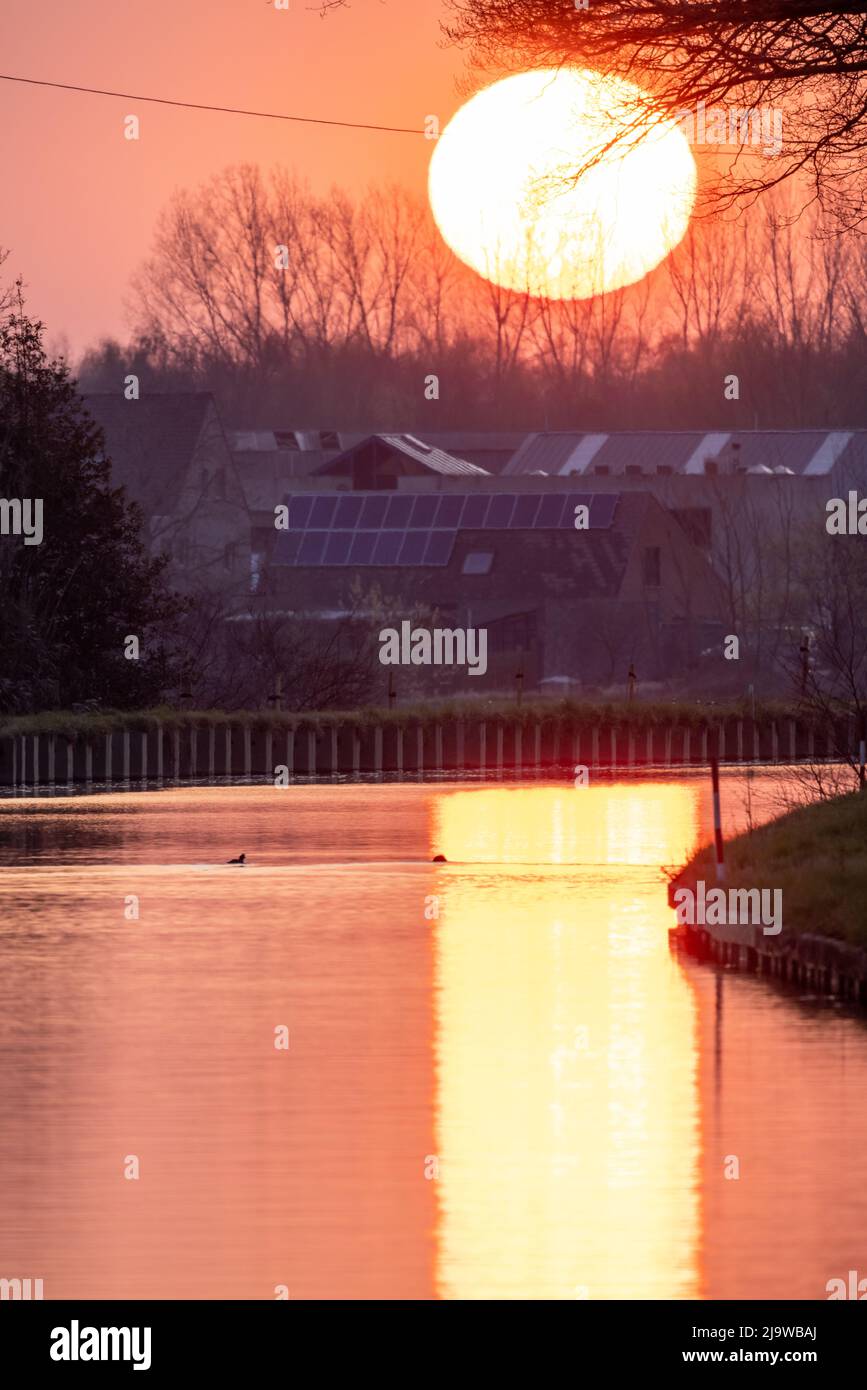 Sonnenuntergang orange See Wasser Reflexion Landschaft. Reflexion des Sonnenuntergangs Wasser. Blick auf den Sonnenuntergang über dem Fluss, orange. Sonnenuntergang Fluss Wasserspiegelung. Hochwertige Fotos Stockfoto