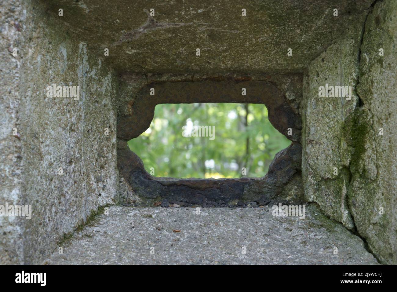 Blick durch das Schießschachtloch nach außen. Ein altes Befestigungsfragment aus dem Ersten Weltkrieg, aus Beton mit einem Lochloch - das kleine Stockfoto