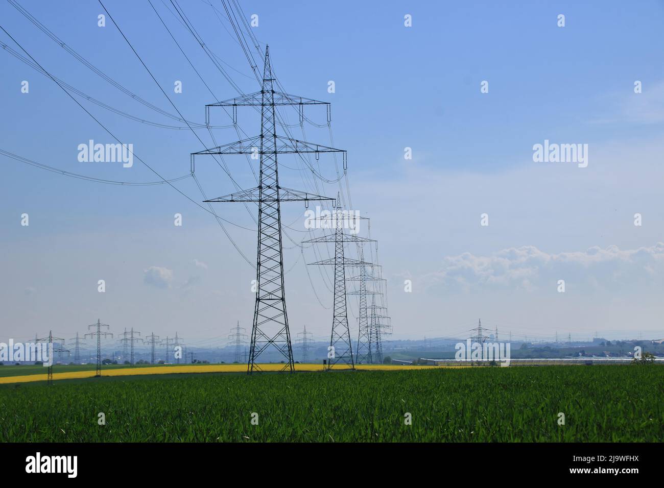 Mehrere Hochspannungsmasten gegen einen blauen Himmel Stockfoto