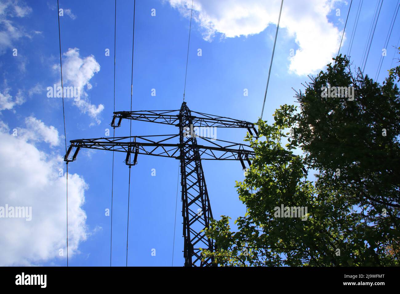 Einzelner Hochspannungs-Pylon gegen einen blauen Himmel Stockfoto