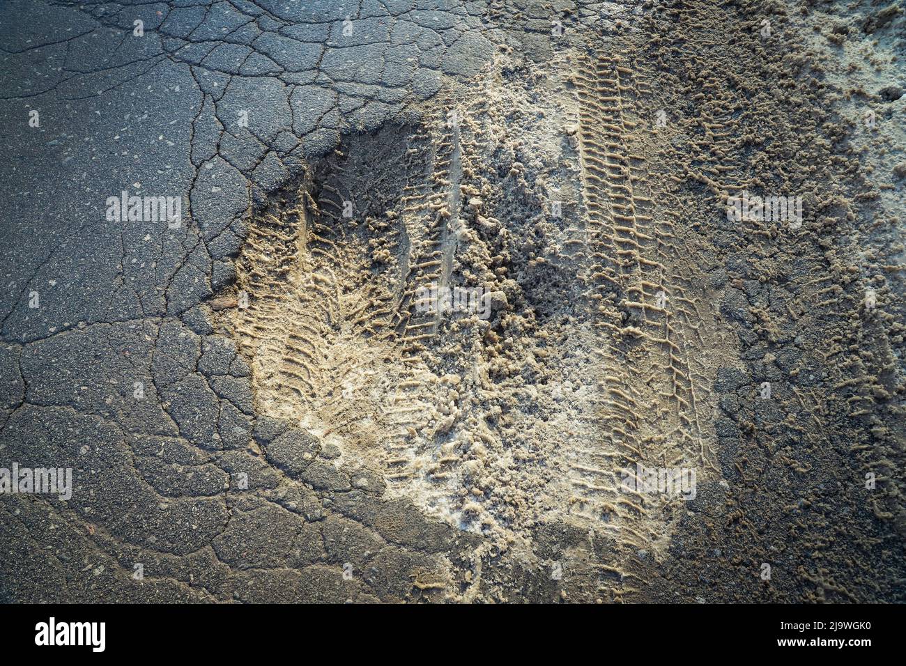 Große Grube an der alten Landstraße im Winter aus nächster Nähe. Schlamm und Schnee. Im Freien Stockfoto