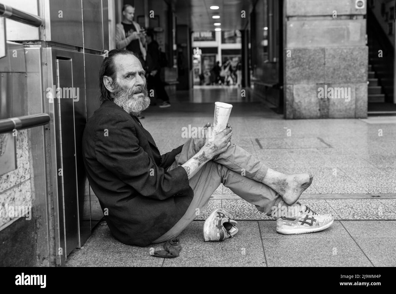 Vor der Victoria Station, London, Großbritannien, saß ein obdachloser Mann mit infiziertem Fuß und bettelte um Geld Stockfoto