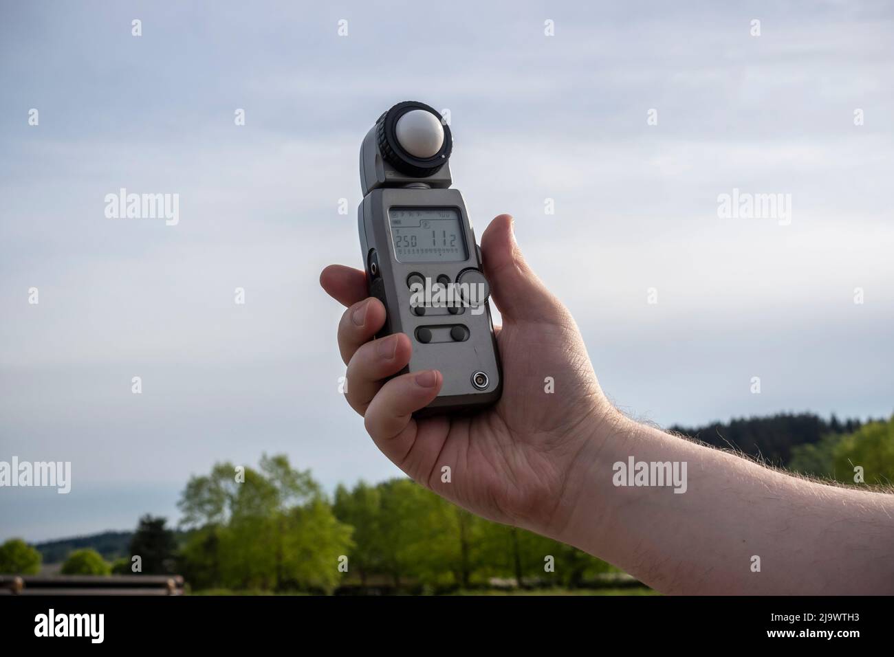 Seattle, WA USA - ca. Mai 2022: Blick auf einen Mann, der einen sekonischen Lichtmesser hält, während er im Freien fotografiert. Stockfoto