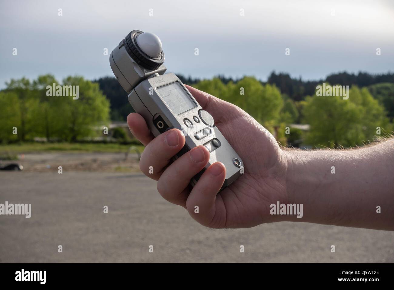 Seattle, WA USA - ca. Mai 2022: Blick auf einen Mann, der einen sekonischen Lichtmesser hält, während er im Freien fotografiert Stockfoto
