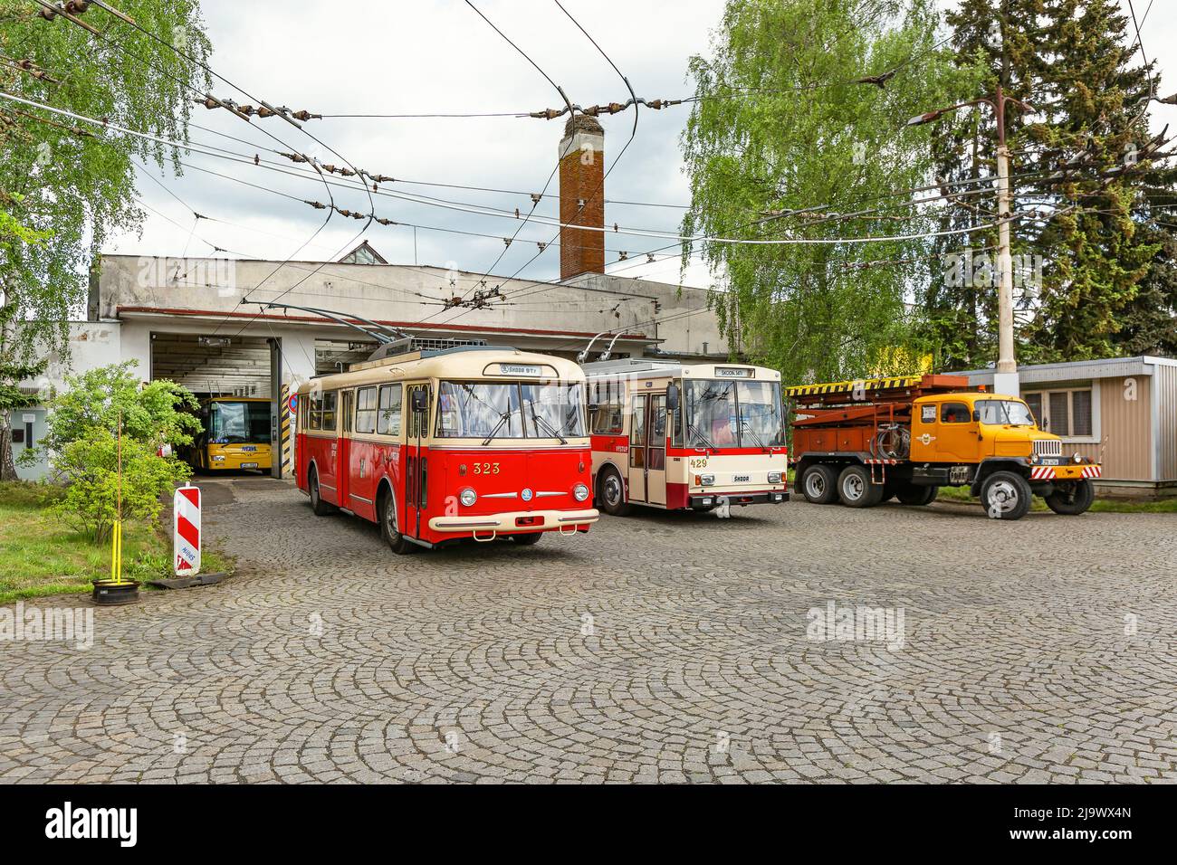 Marienbad, Tschechische Republik - Mai 21 2022: Zwei Skoda-Trolleybusse, 9Tr und 14Tr, stehen vor einer Garage auf grauem Pflastersteinpflaster. Jahrestag von Stockfoto