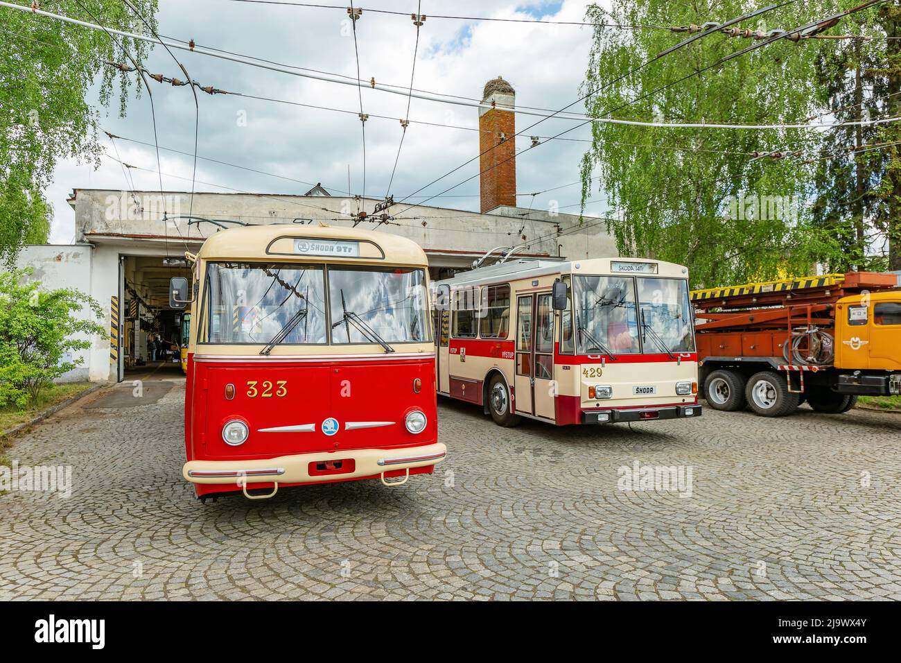 Marienbad, Tschechische Republik - Mai 21 2022: Zwei Skoda-Trolleybusse, 9Tr und 14Tr, stehen vor einer Garage auf grauem Pflastersteinpflaster. Jahrestag von Stockfoto