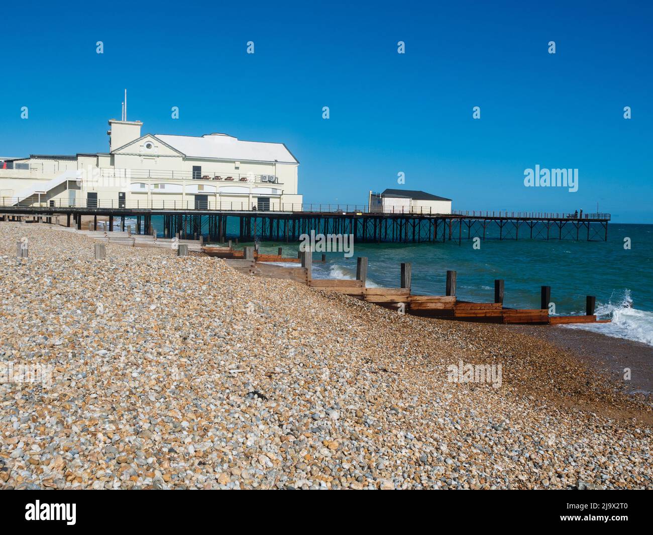 Wellen brechen am Kiesstrand vor dem Pier in Bognor Regis, West Sussex, Großbritannien Stockfoto