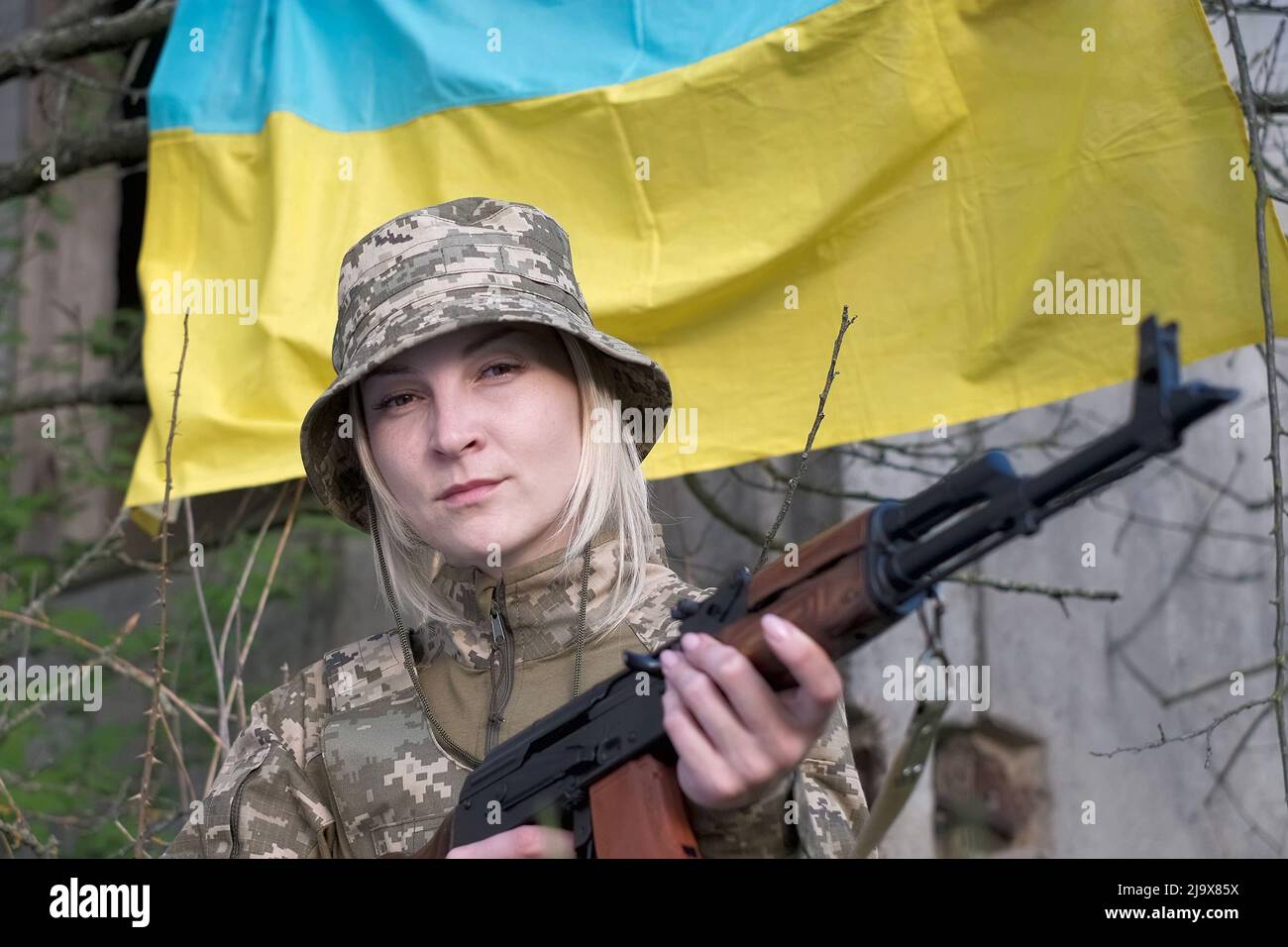 Porträt einer Soldatinnen in Tarnuniform, die auf die Kamera schaut Stockfoto