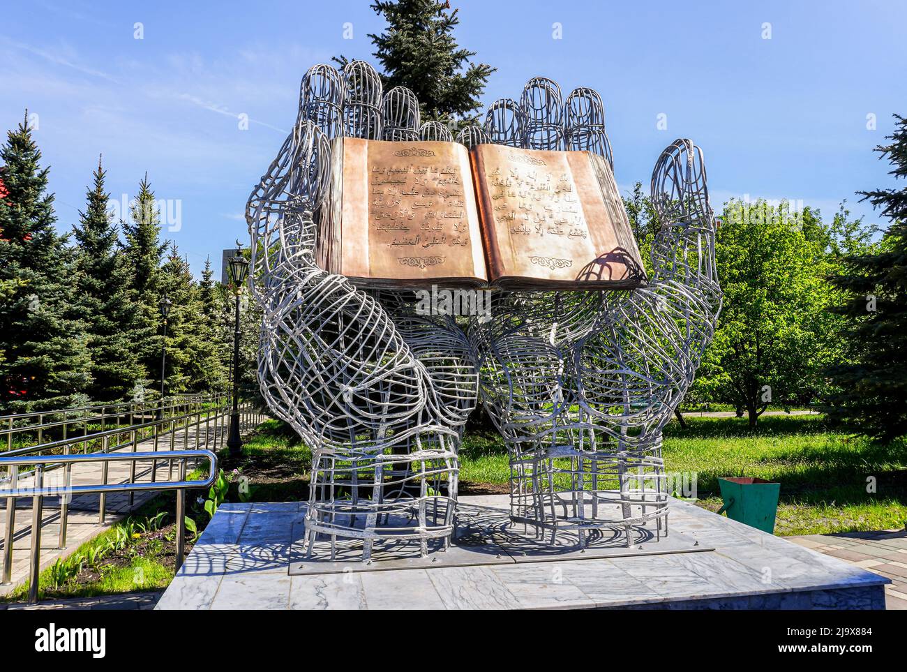 Samara, Russland - 8. Mai 2022: Skulpturale Komposition 'Quran in offenen Palmen' auf dem Territorium der Samara-Kathedrale-Moschee. Arabischer Text: Surahs von t Stockfoto