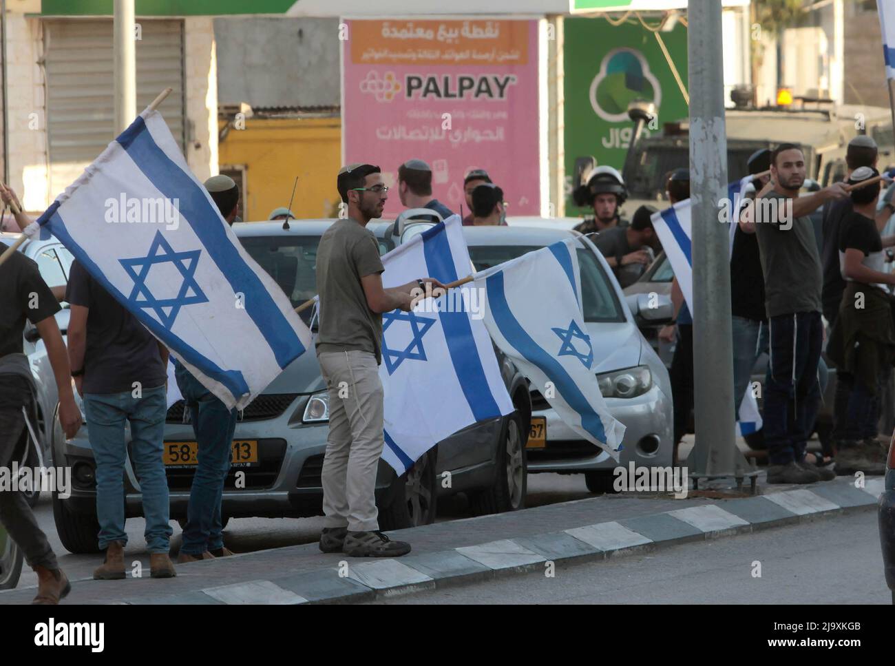 Nablus, Palästina. 12.. Mai 2022. Jüdische Siedler demonstrieren während eines „Marsches für Flaggen“ mitten auf dem Markt in der Stadt Hawara, südlich von Nablus im Westjordanland, winkende Fahnen. (Foto von Nasser Ishtayeh/SOPA Images/Sipa USA) Quelle: SIPA USA/Alamy Live News Stockfoto