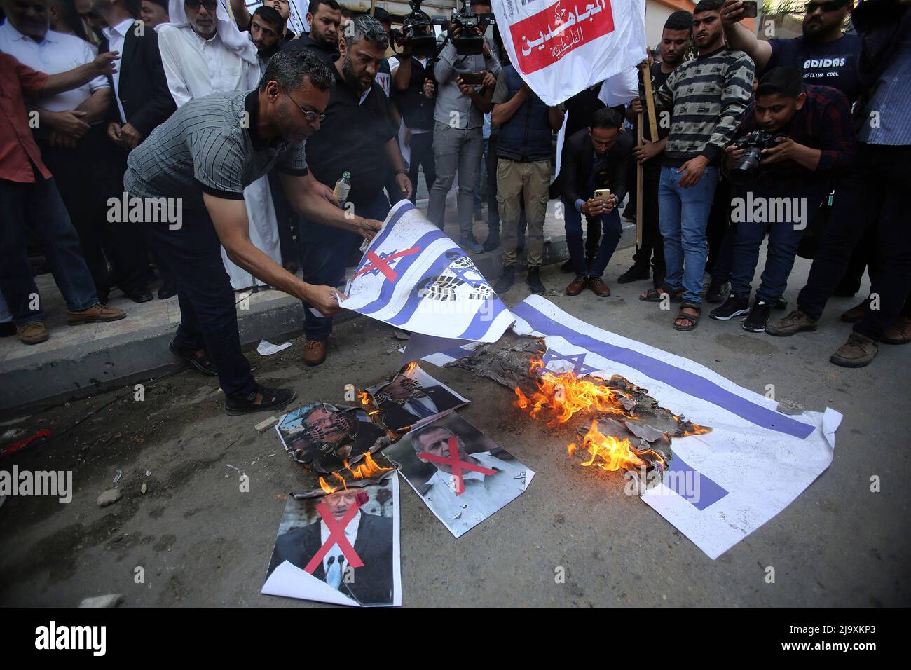 Gaza, Palästina. 25.. Mai 2022. Während des Protestes verbrennen Palästinenser israelische Flaggen und Porträts israelischer Beamter (Naftali Bennett, Premierminister von Israel, Benjamin Gantz, Stellvertretender Premierminister von Israel und Verteidigungsminister und Aviv Kochavi, Kommandeur der israelischen Armee). Palästinensische Fraktionen organisierten einen Protest gegen den so genannten „Flaggenmarsch“ des Jerusalem-Tages, der in Jerusalem in der Nähe der islamischen Stadtteile am folgenden Sonntag, dem 29.. Mai 2022, in Gaza-Stadt stattfinden wird. (Foto von Ahmed Zakot/SOPA Images/Sipa USA) Quelle: SIPA USA/Alamy Live News Stockfoto