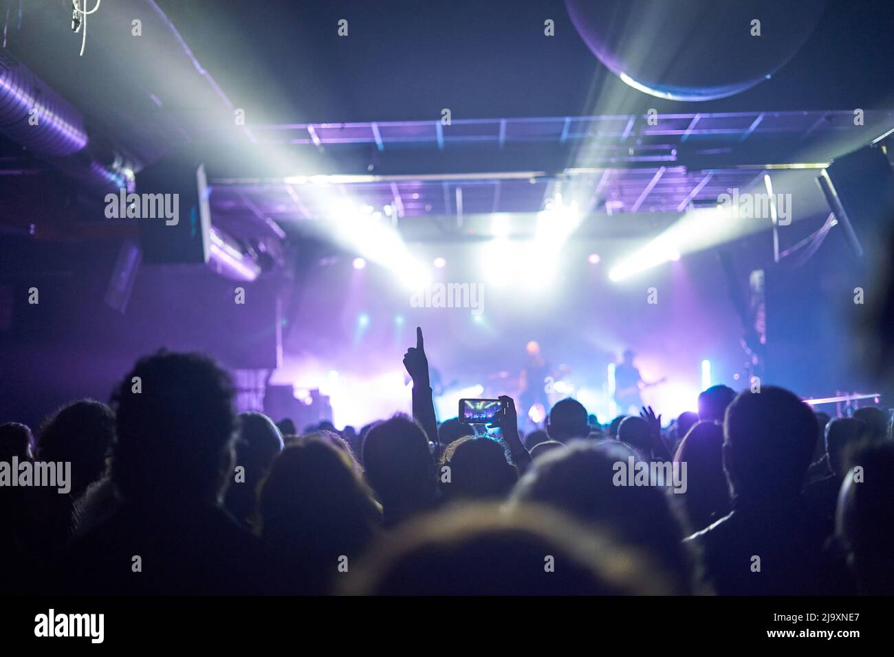 Sillhouettes Of Concert Crowd Vor Hellen Bühnenlichtern Stockfoto