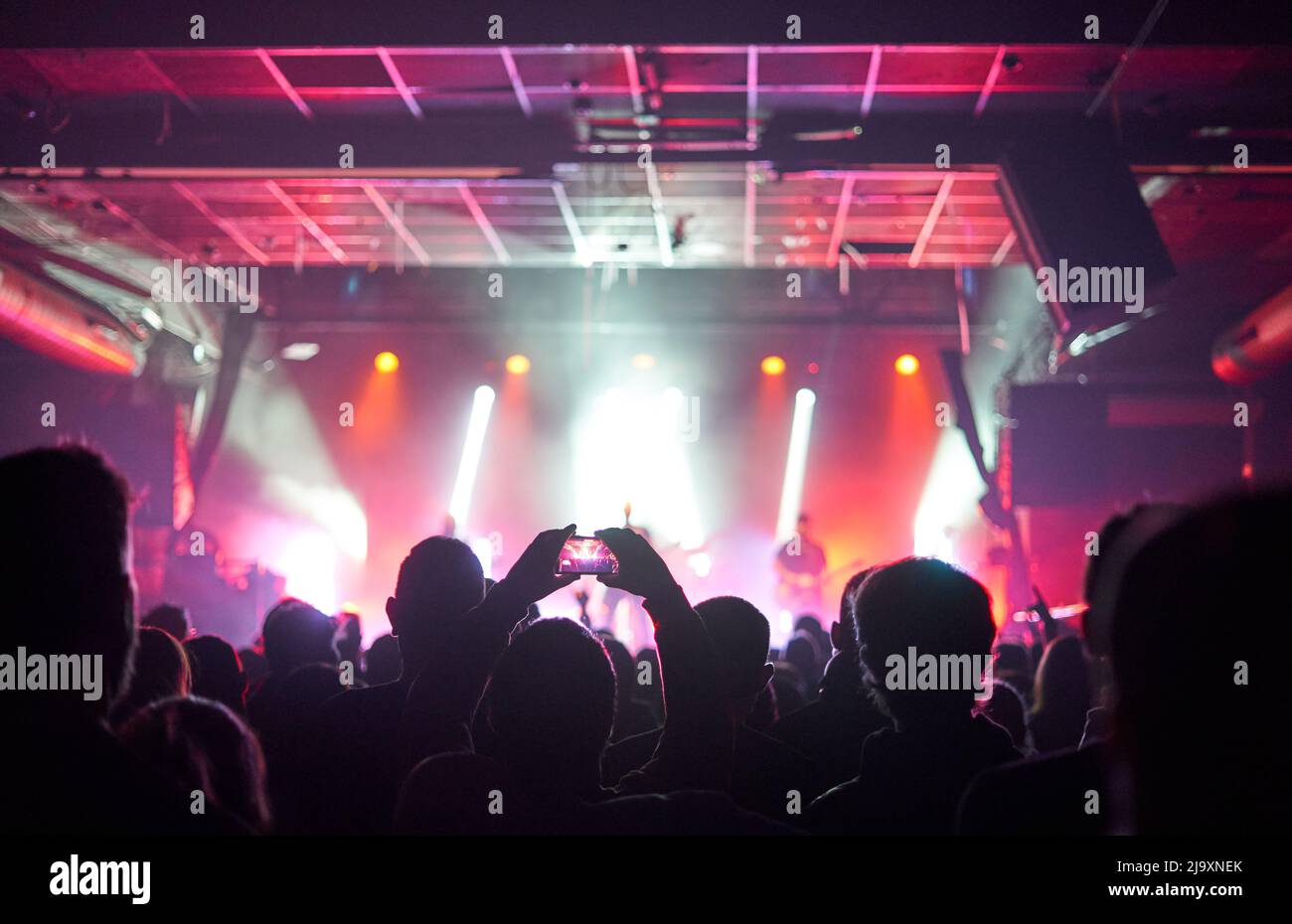 Sillhouettes Of Concert Crowd Vor Hellen Bühnenlichtern Stockfoto