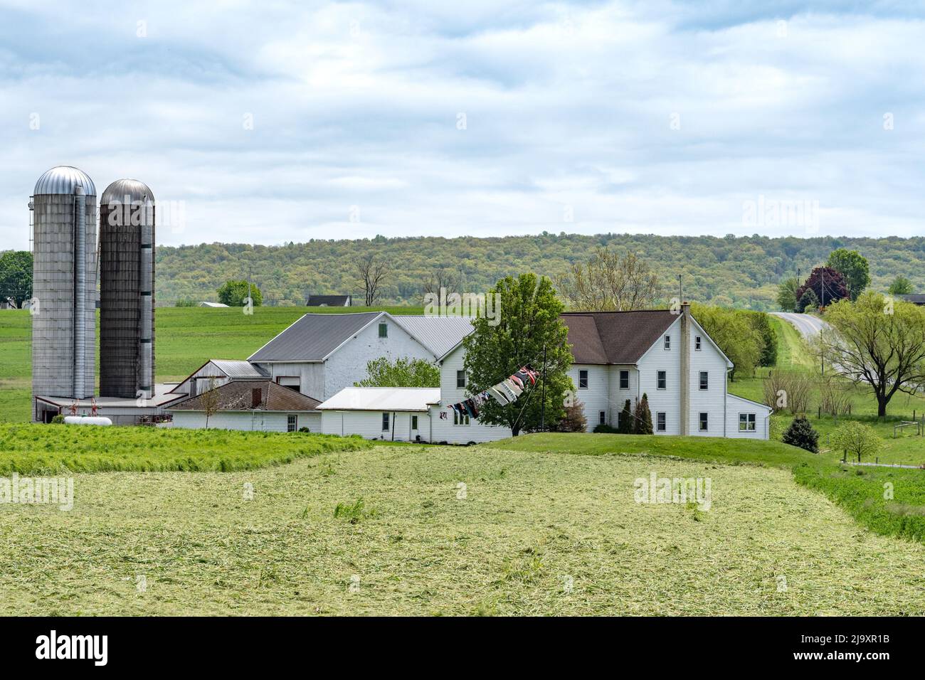 Amish Farm mit einer weiß gewaschenen Scheune und Wäscheständer auf Wäscheleine. Stockfoto