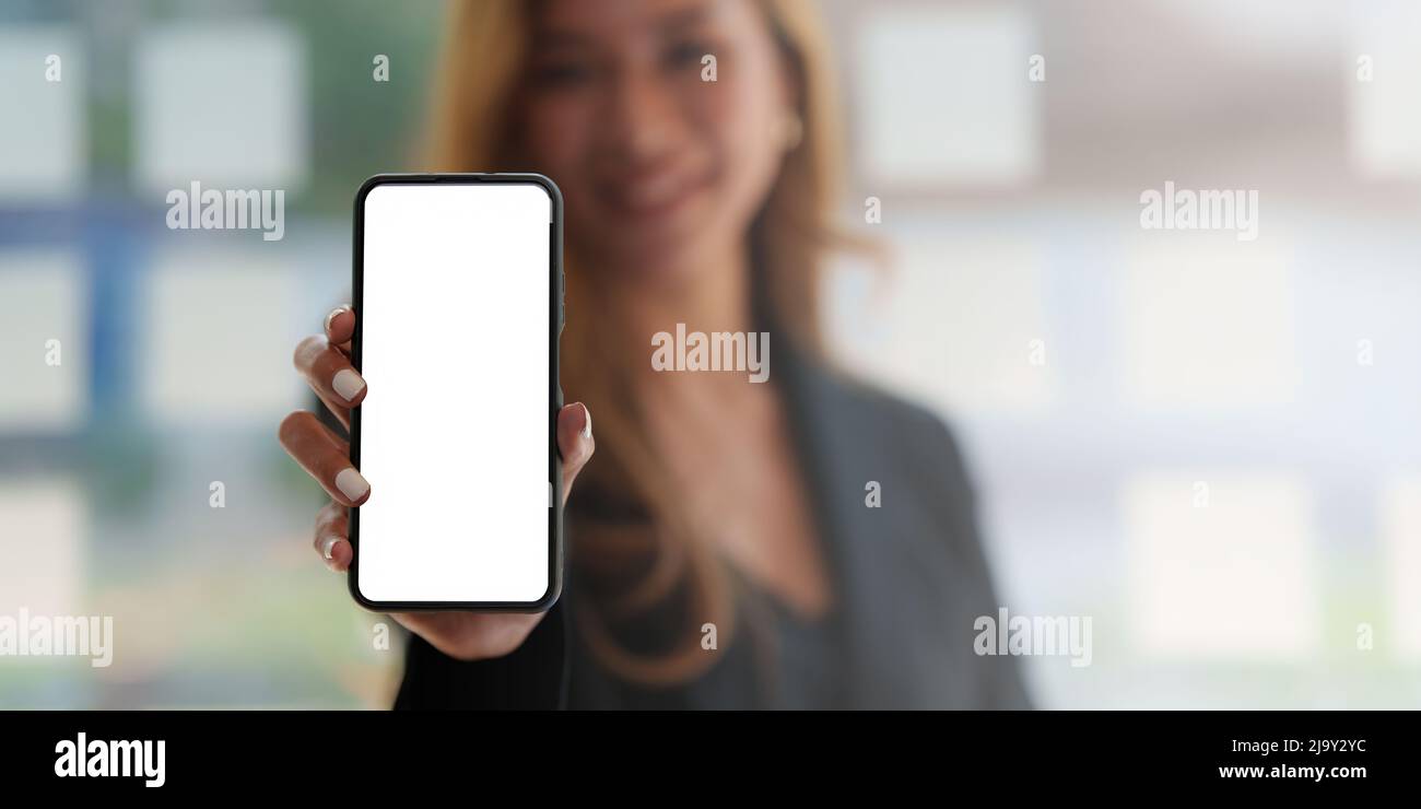 Eine Frau aufgeregt Überraschung und zeigt Handy-Bildschirm. Leerer Bildschirm für Ihre Werbung. Stockfoto