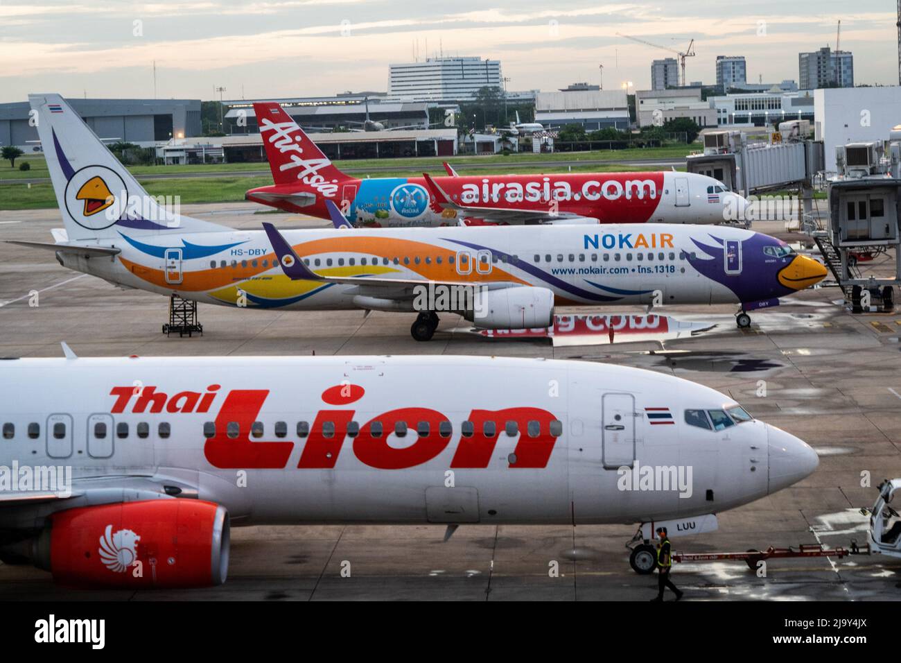 Kommerzielle Airbus A320-200-Flugzeuge für Thai AirAsia (FD), NokAir und Thai Lion werden vor den nationalen Abflugtoren am Don Mueang International Airport (DMK) in Bangkok geparkt. Internationale Reisen nach Thailand und inländischer Tourismus im Land werden wieder aufgenommen, da die thailändische Regierung die Einreisebestimmungen im Rahmen ihres Thailand Pass-Programms vereinfacht, so dass internationale Reisende das Land ohne einen schnellen PCR-Test für COVID-19 oder Quarantäne bei der Ankunft betreten können. Die thailändische Regierung hat auch signalisiert, dass die Auflage, Gesichtsmasken im Freien zu tragen, voraussichtlich Mitte Juni 2022 enden wird. Stockfoto