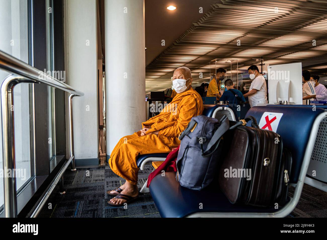 Bangkok, Thailand. 26.. Mai 2022. Ein buddhistischer Mönch mit Gesichtsmaske wartet auf einen Abflug am Don Mueang International Airport (DMK) in Bangkok. Internationale Reisen nach Thailand und inländischer Tourismus im Land werden wieder aufgenommen, da die thailändische Regierung die Einreisebestimmungen im Rahmen ihres Thailand Pass-Programms vereinfacht, so dass internationale Reisende das Land ohne einen schnellen PCR-Test für COVID-19 oder Quarantäne bei der Ankunft betreten können. Die thailändische Regierung hat auch signalisiert, dass die Auflage, Gesichtsmasken im Freien zu tragen, voraussichtlich Mitte Juni 2022 enden wird. Kredit: SOPA Images Limited/Alamy Live Nachrichten Stockfoto