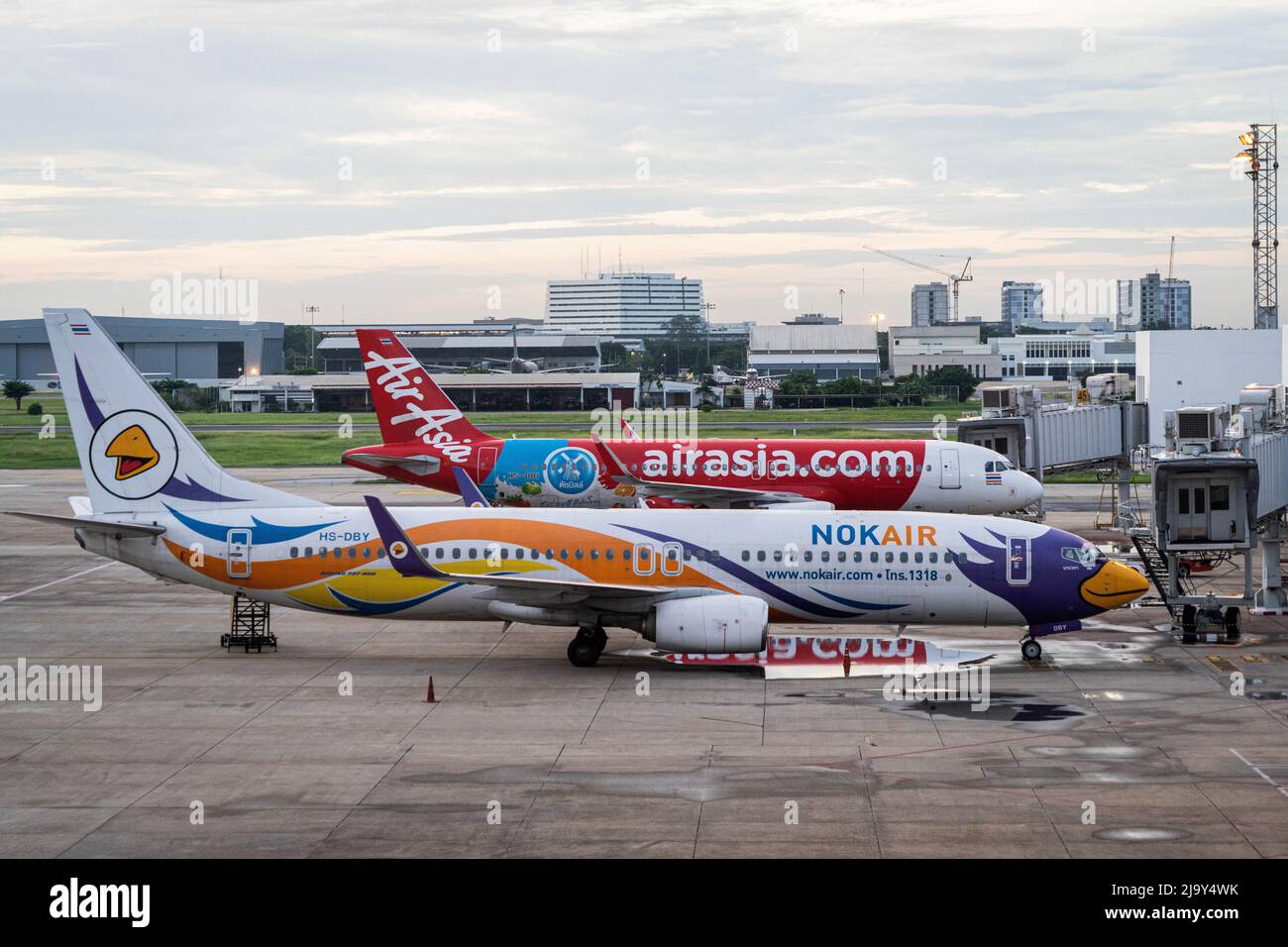 Kommerzielle Airbus-Flugzeuge vom Typ A320-200 für Thai AirAsia (FD) und NokAir werden am Don Mueang International Airport (DMK) in Bangkok vor den nationalen Abfluggates geparkt. Internationale Reisen nach Thailand und inländischer Tourismus im Land werden wieder aufgenommen, da die thailändische Regierung die Einreisebestimmungen im Rahmen ihres Thailand Pass-Programms vereinfacht, so dass internationale Reisende das Land ohne einen schnellen PCR-Test für COVID-19 oder Quarantäne bei der Ankunft betreten können. Die thailändische Regierung hat auch signalisiert, dass die Auflage, Gesichtsmasken im Freien zu tragen, voraussichtlich Mitte Juni 2022 enden wird. (Foto von Matt Hunt Stockfoto