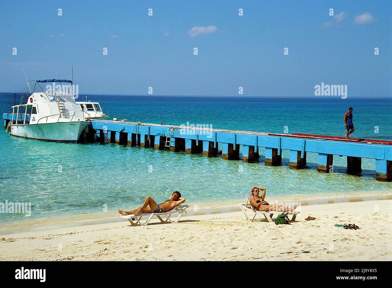 Touristen sonnen sich auf Liegestühlen am Strand von Maria la Gorda, Pinar del Rio, Kuba, Karibik | Touristen sonnen sich am Strand von Maria la Gord Stockfoto