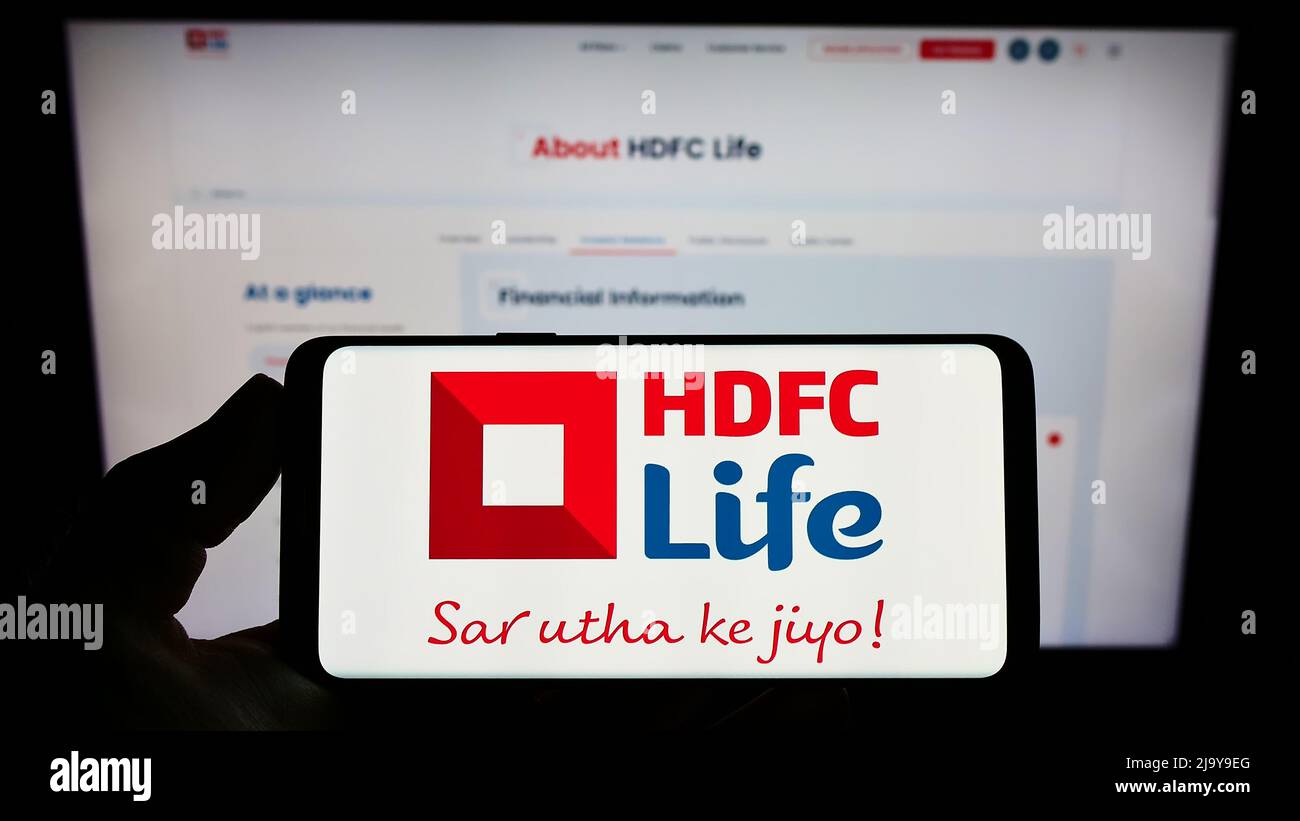 Person mit Mobiltelefon und Logo der indischen HDFC Life Insurance Company Ltd. Auf dem Bildschirm vor der Webseite. Konzentrieren Sie sich auf die Telefonanzeige. Stockfoto