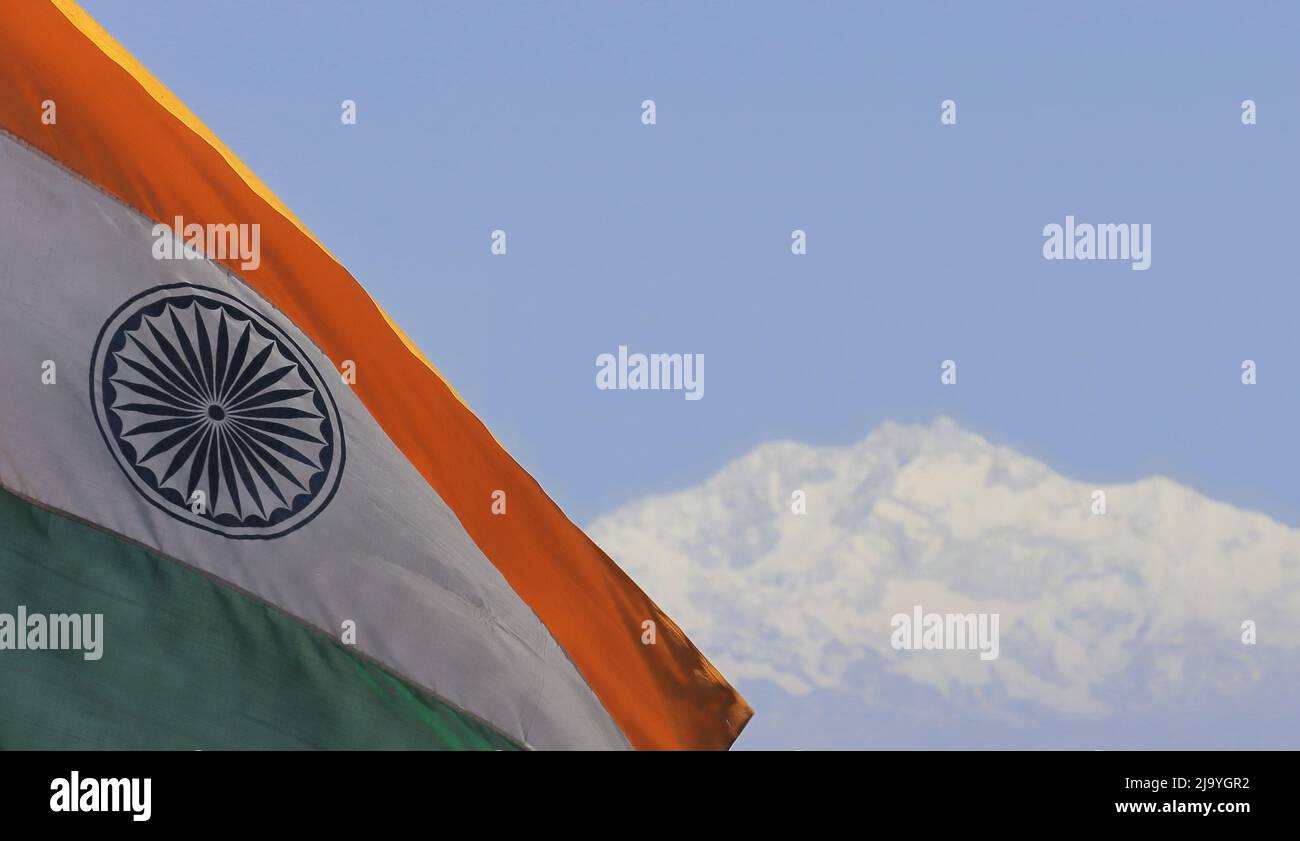 dreifarbige indische Nationalflagge und schneebedeckte himalaya-Berge (der höchste Berg indiens, der kanchenjunga) mit blauem Himmel im Hintergrund Stockfoto